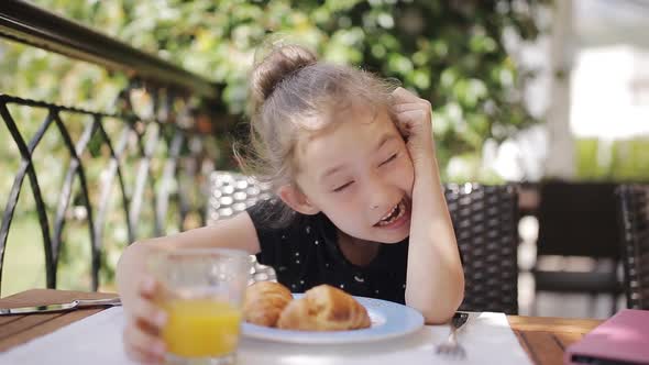 Adorable Girl Having Breakfast at Outdoor Cafe