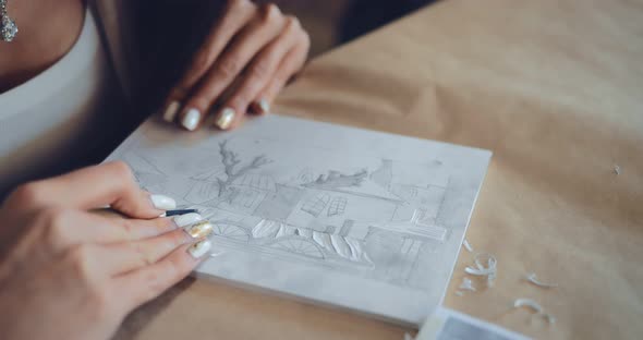 Hand of the Master's Girl in Linocuts Cuts Out a Drawing on a Plastic Tablet