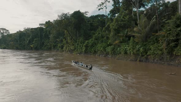Aerial shot of Amazon river and dense forest . Small boat with local people on the Javari River, Ama