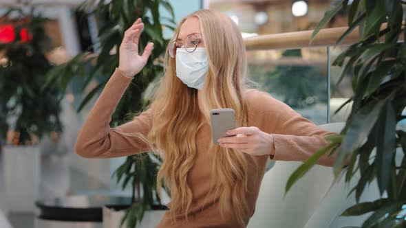 Displeased Blonde Caucasian Woman in Medical Mask Looking at Smartphone Screen Dissatisfied with Bad