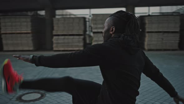 Active African American Athlete Warming Up Before Run Practice Stretching and Lifting His Legs