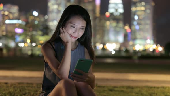 Woman looking at cellphone at night 