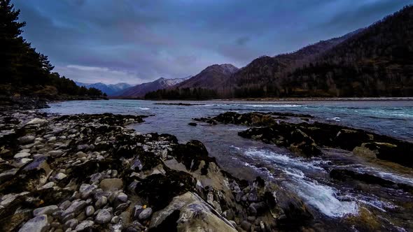 Time Lapse Shot of a River Near Mountain Forest. Huge Rocks and Fast Clouds Movenings