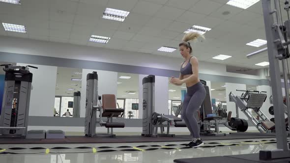 Young woman cardio exercising jumping at gym fitness center