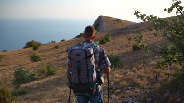 Young American Man is Hiking While Traveling in Countryside on Autumn Day Spbd