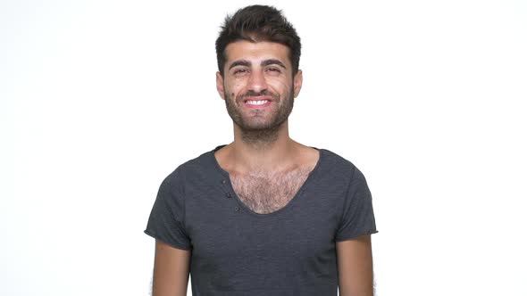 Hispanic Young Man Wearing Grey Tshirt Looking at Camera Smiling Broadly with White Teeth Showing