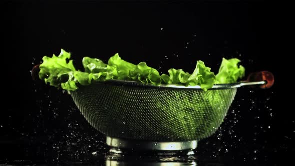 A Colander with Lettuce Leaves Will Fall on the Table