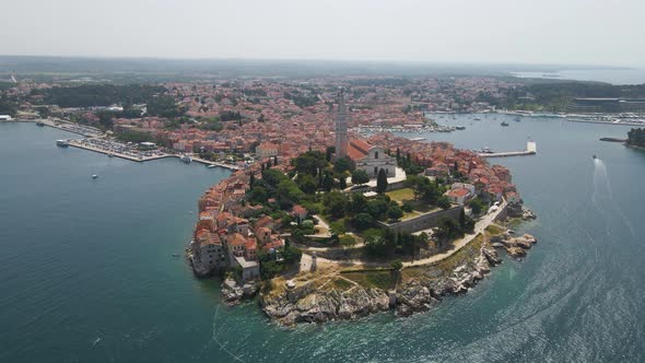 Aerial rotating backward shot of St. Euphemia church with the view of medieval old town in Rovinj in