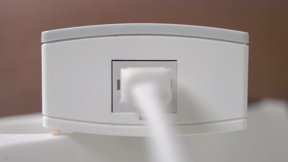 Connecting network internet plug in a white wireless modem on a brown background