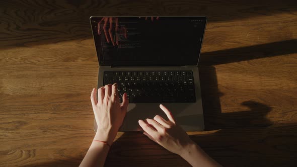 Top View Caucasian Woman Hands Scrolling on the Touchpad While Reviewing Css Code on Her Laptop