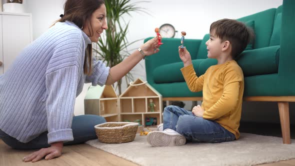 Educational Therapist Playing Game with Little Child with Wooden Toy to Help Him to Improve His