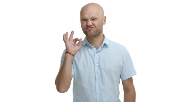 Handsome Middleaged Bald Man with Bristle Praise Something Good Showing Okay Sign and Nodding in