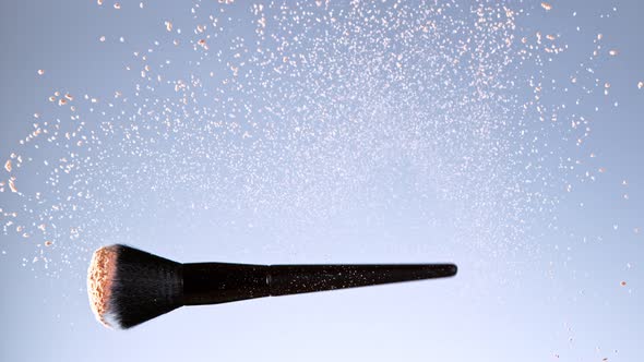 Super Slow Motion Shot of Flying and Rotating Makeup Brush and Brown Powder at 1000Fps