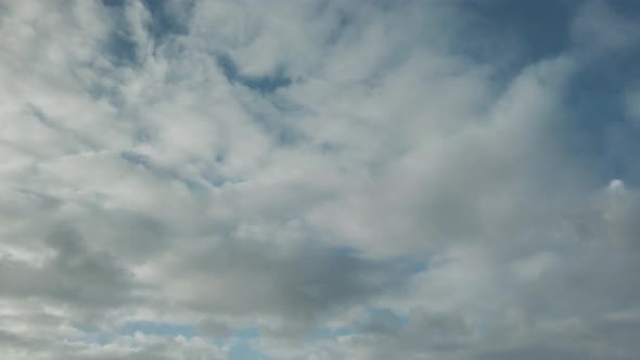 Clouds in front of a blue skying by in the wind