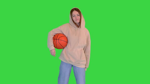 Young Girl Holding a Basketball Smiling to Camera on a Green Screen Chroma Key