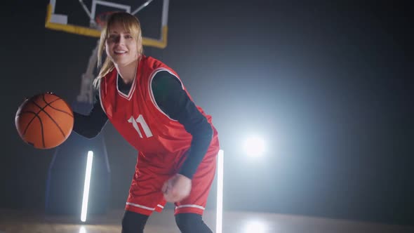 Portrait of Cheerful Sporty Female Basketball Player Hits the Ball Off the Floor and Warms Up Before