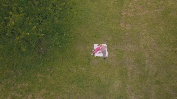 Family Weekend Picnic in Park. Aerial View. Senior Old Couple Lie on Blanket on Green Grass Meadow