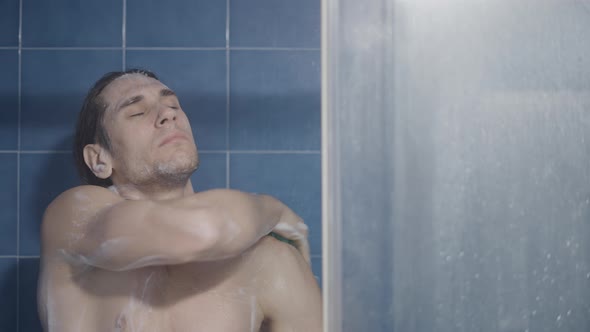 Young Caucasian Longhaired Man Rubbing His Armpits and Back in the Shower  Close Up Shot