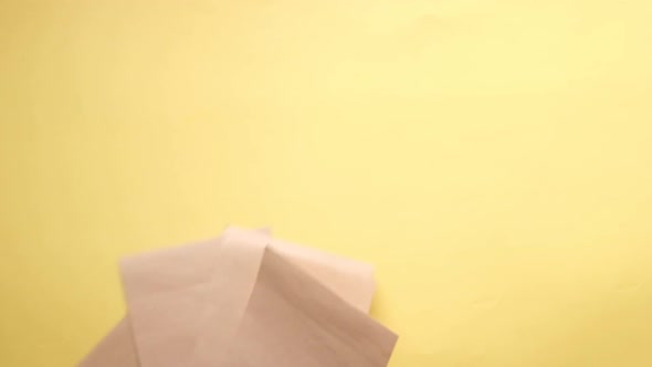 Slow Motion of Empty Paper Dropping on Yellow Background