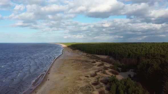 Garciems Beach, Latvia Baltic Sea Suny Winter Day Big Clouds Sand Dunes With Pine Trees. Aerial 4K