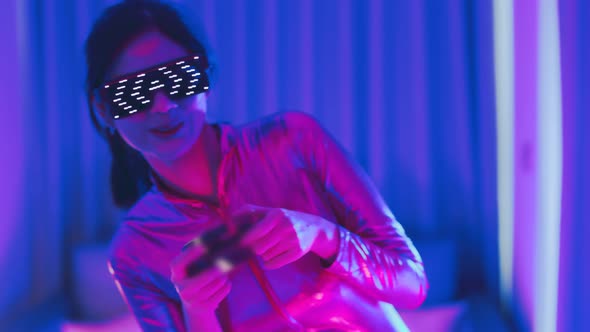 Young asian woman is using virtual reality headset. Neon light studio portrait
