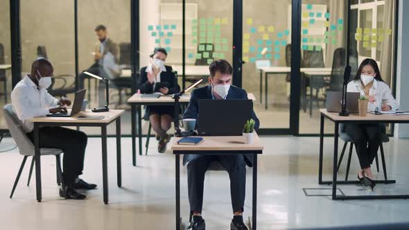 Modern International Office Office Workers and Managers in Medical Masks Working at Computers