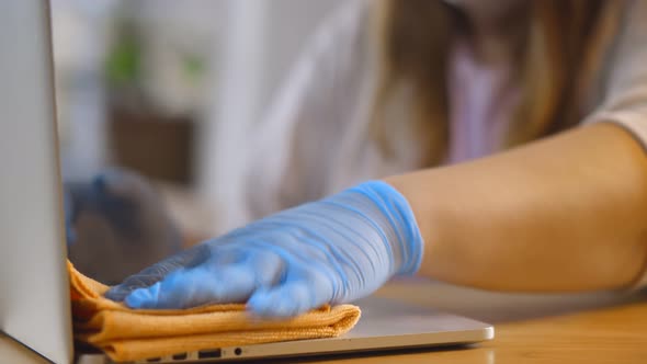 Close Up of Woman in Gloves Cleaning and Wiping Laptop Computer with Disinfector