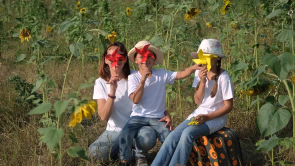 Family Play with Pinwheel Toys in Sunflower Field