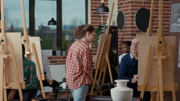 Art Lesson Teacher Supervising Students Drawing Vase Model