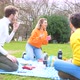 Four multiethnic friends having picnic in a park in group having fun - VideoHive Item for Sale