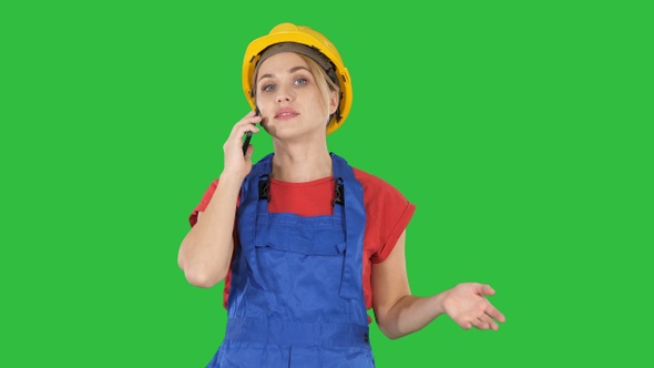 Young female worker talking on phone while walking