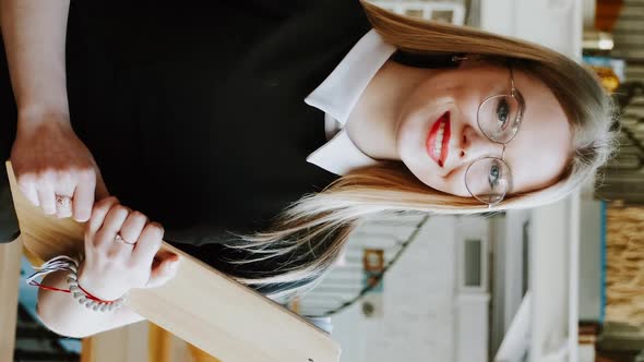 Vertical Screen Smiling Waitress Girl in Empty Restaurant When It's Closed