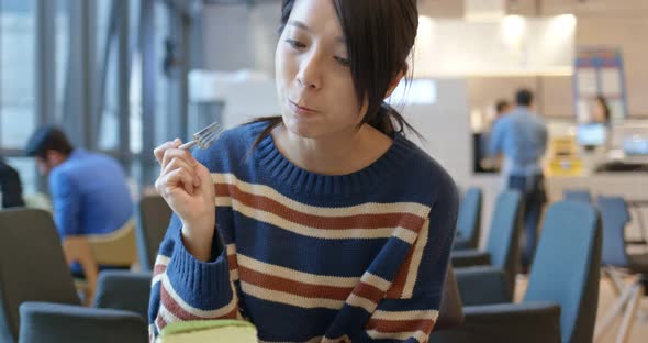 Asian Woman enjoy the cake in coffee shop