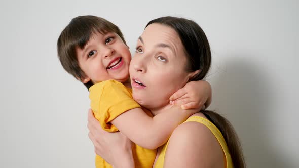 Boy Hugs His Mom Tightly Dressed in Yellow Poppies