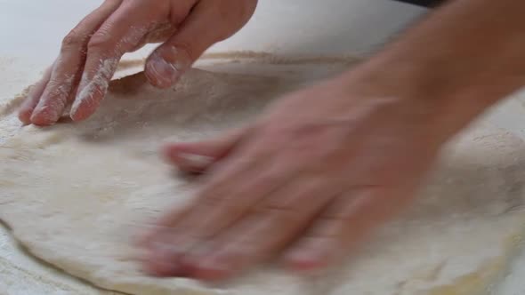 Professional Chef Stretches and Twists Soft Italian Pizza Dough with His Hands
