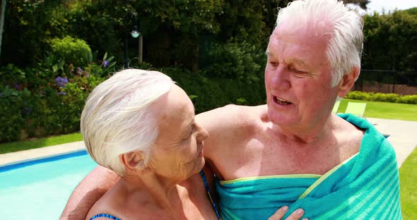 Senior couple kissing each other in the poolside
