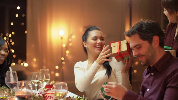 Friends Having Christmas Feast and Giving Presents