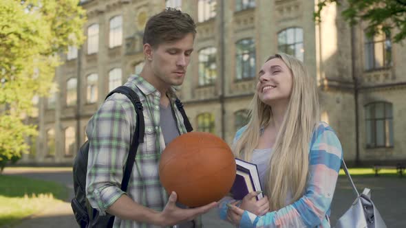 Young Man Talking With Beautiful Blonde Near College, Trying to Impress Girl