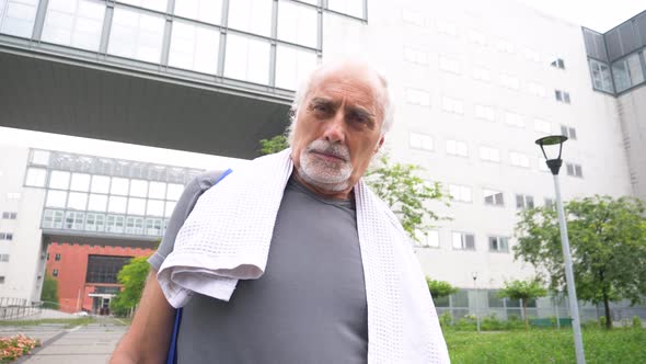 Senior athletic man with towel during break