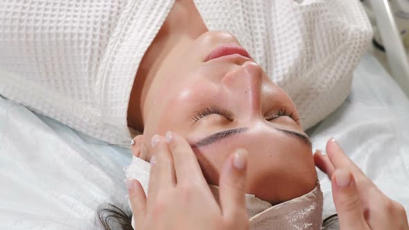 Wellness and Beauty Salon. Relaxed Woman Lying on Couch and Having Deep Cleansing Nourishing Facial