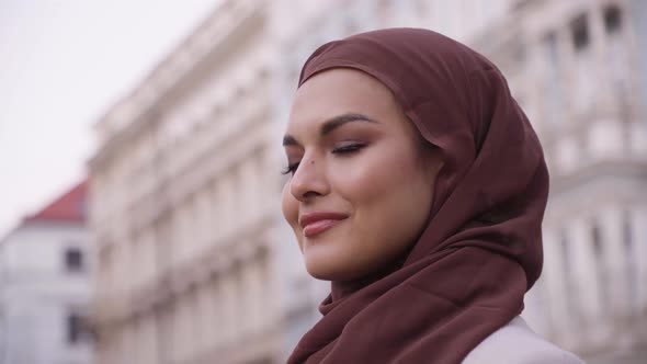 A Young Beautiful Muslim Woman Smiles at the Camera in a Street in an Urban Area