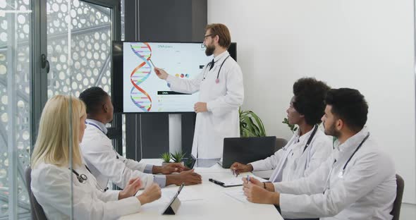 Doctor which Explaining the Dna Structure for His Concentrated Multiethnic Colleagues