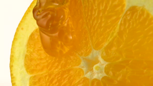 Honey pouring on orange, Slow Motion alt