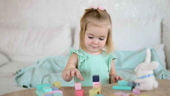 Adorable Little Girl Playing with Colorful Wooden Cubes