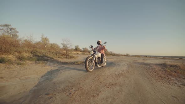 Motorcyclist Driving His Motorbike on the Dirt Road During Sunset Slow Motion