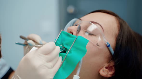 Young female at dentist office. Close up medical dentist procedure of teeth