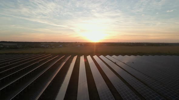 Aerial Drone View Into Large Solar Panels at a Solar Farm at Bright Sunset. Solar Cell Power Plants