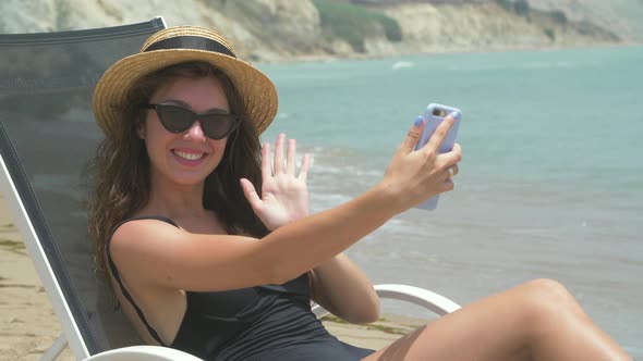 Beautiful Smiling Woman Lying on Deck Chair 