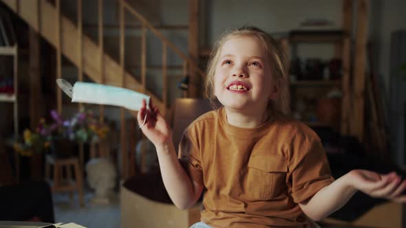 The Girl Does Not Understand Why She Needs to Wear a Medical Mask and Throws It Away