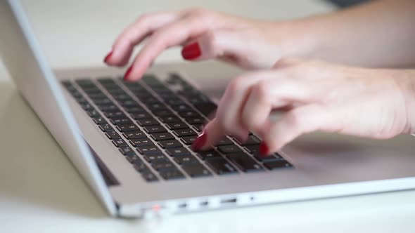 Close Up on Female Hands with Red Nail Polish Working on a Laptop Concept of Working From Home